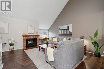 Collingwood townhouse for rent - A living room with a grey couch and a fireplace.