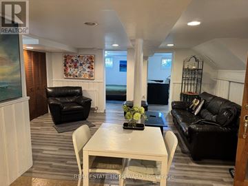 Mississauga (Mineola) apartment for rent - A living room with a white table and black leather couches.