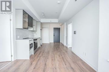 Oakville (Go Glenorchy) condo for rent - A spacious kitchen with white cabinets and a wooden floor.