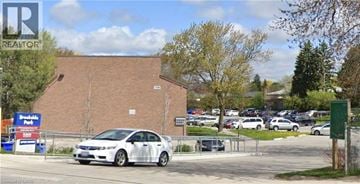 Kitchener townhouse for rent - A white car is parked in a lot with a sign that says REALTOR.