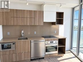 Toronto (Waterfront Communities) condo for rent - A modern kitchen with wooden cabinets and stainless steel appliances.