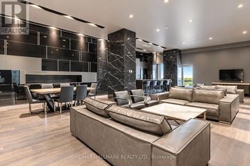 Toronto (Waterfront Communities) condo for rent - A modern living room with a large sectional sofa and a dining table.