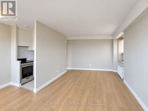Toronto (Annex) condo for rent - A spacious room with wooden flooring and a kitchenette in the corner.
