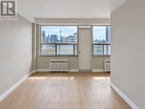 Toronto (Annex) condo for rent - A room with a view of the city skyline through the window.
