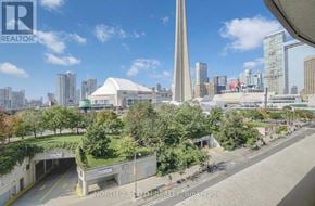 Toronto (Waterfront Communities) condo for rent - A cityscape with a tall monument in the center and a bridge in the foreground.