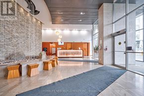 Mississauga (City Centre) condo for rent - A lobby with a stone wall and a glass wall.