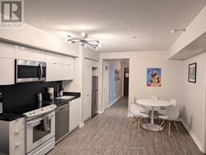 Toronto (Waterfront Communities) condo for rent - A kitchen with white cabinets and a black countertop.