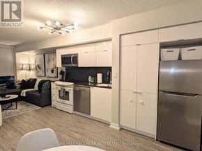 Toronto (Waterfront Communities) condo for rent - A modern kitchen with white cabinets and stainless steel appliances.