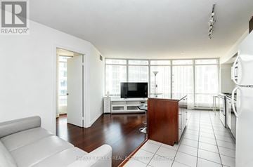 Toronto (Waterfront Communities) condo for rent - A living room with a white couch and a television.