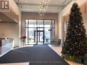 Markham (Unionville) condo for rent - A Christmas tree stands next to a set of double doors in a lobby.
