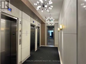 Markham (Unionville) condo for rent - A hallway with elevators and a chandelier.