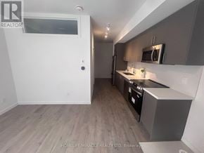 Markham (Middlefield) townhouse for rent - A kitchen with a microwave above the stove and a refrigerator to the left.