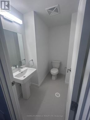 Markham (Middlefield) townhouse for rent - A white bathroom with a sink, toilet and mirror.