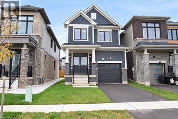 Caledonia apartment for rent - A large, modern house with a black front door and a garage.