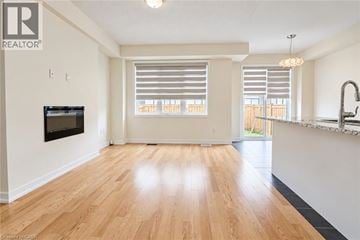 Caledonia apartment for rent - A spacious living room with wooden flooring and a television mounted on the wall.