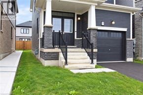 Caledonia apartment for rent - A modern house with a black front door and a black garage door.