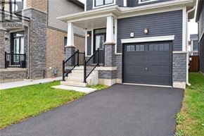 Caledonia apartment for rent - A house with a black garage door and a stone wall.