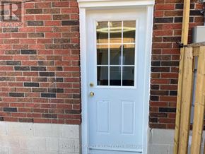 Hamilton (Riverdale) apartment for rent - A white door with a glass window is set in a brick wall.