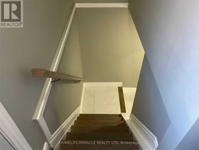 Hamilton (Riverdale) apartment for rent - A staircase with a wooden handrail and white walls.
