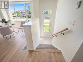 Cobourg townhouse for rent - A room with a staircase leading to a door with a view of a green lawn.