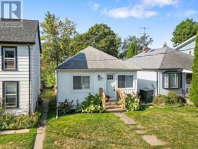 St. Catharines (Port Dalhousie) apartment for rent - A white house with a grey roof is surrounded by greenery and other houses.