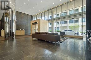 Toronto (Niagara) condo for rent - A lobby with a large glass wall and a brown couch.