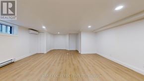 Toronto (Lawrence Park South) multi-family for rent - A spacious room with wooden flooring and white walls, with a window on the left side.