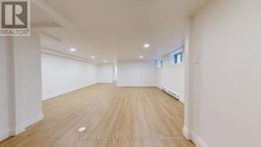 Toronto (Lawrence Park South) multi-family for rent - A spacious room with wooden flooring and white walls, presented by Harvey Kalles Real Estate Ltd.