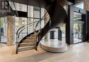 Toronto (Forest Hill South) condo for rent - A modern staircase in a building with a glass wall in the background.
