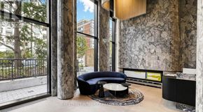 Toronto (Forest Hill South) condo for rent - A black chair sits in front of a marble wall in a room with a view of the street outside.