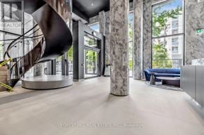 Toronto (Forest Hill South) condo for rent - A modern office lobby with a spiral staircase and marble columns.