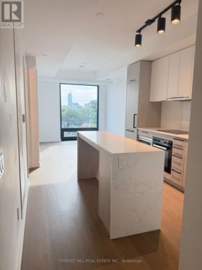 Toronto (Forest Hill South) condo for rent - A modern kitchen with a marble island and wooden floors.