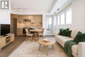 Toronto (East End-Danforth) condo for rent - A modern living room with a dining table and chairs.