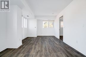 Toronto (East End-Danforth) condo for rent - A spacious room with wooden flooring and white walls.