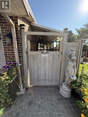 Toronto (Guildwood) apartment for rent - A wooden gate with a sign on it and a statue in front of it.