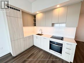 Vaughan (Vaughan Corporate Centre) condo for rent - A kitchen with white cabinets and a wooden floor.