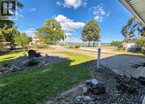 Windsor apartment for rent - A sunny day at a residential area with a house and a tree in the background.