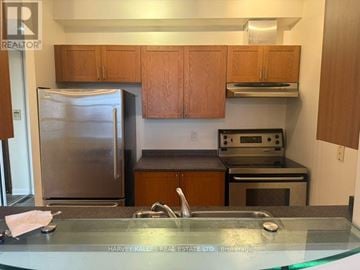 Toronto (Waterfront Communities) condo for rent - A kitchen with a refrigerator, oven, and cabinets.