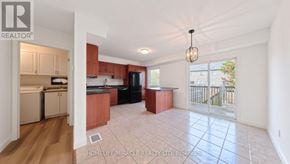 Kitchener townhouse for rent - A well-lit, spacious living area with a kitchen in the background.