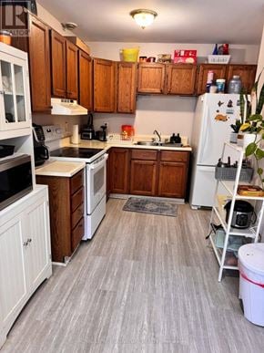 Orangeville townhouse for rent - A kitchen with wooden cabinets and a white refrigerator.