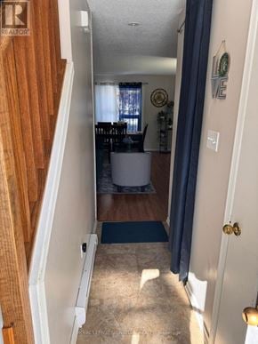 Orangeville townhouse for rent - A hallway with a door on the right and a staircase on the left.