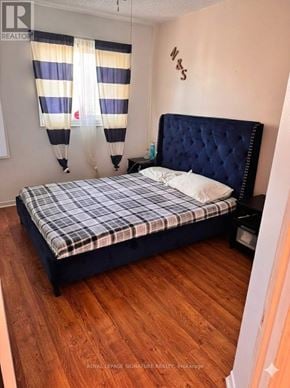 Orangeville townhouse for rent - A bedroom with a dark blue bed and striped curtains.