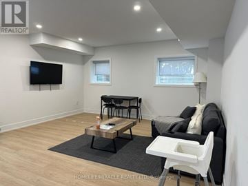 Mississauga (Lakeview) apartment for rent - A living room with a black couch, a coffee table, and a flat screen TV mounted on the wall.