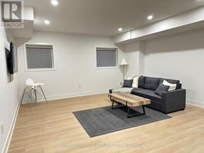 Mississauga (Lakeview) apartment for rent - A living room with a black couch, a wooden coffee table, and a white chair.