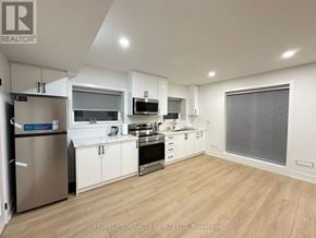 Mississauga (Lakeview) apartment for rent - A well-lit kitchen with wooden floors and white cabinetry.