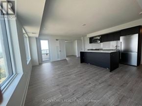 Toronto (Etobicoke West Mall) condo for rent - A spacious kitchen with a refrigerator and stove top oven.