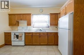 Niagara Falls apartment for rent - A kitchen with wooden cabinets and white appliances.