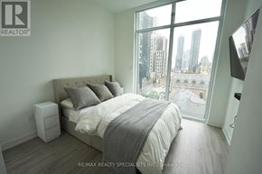 Toronto (Church-Yonge Corridor) condo for rent - A bedroom with a large bed and a city view through the window.