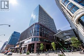 Toronto (Waterfront Communities) condo for rent - A modern glass building stands tall in the city center.