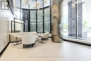 Toronto (Waterfront Communities) condo for rent - A modern office lobby with a glass wall and a white reception desk.